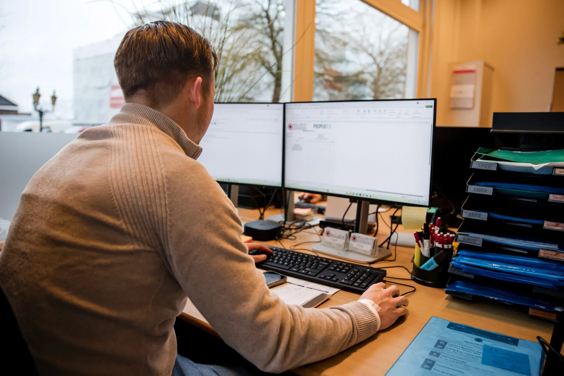 man in green and black plaid long sleeve shirt holding red and black cordless hand drill