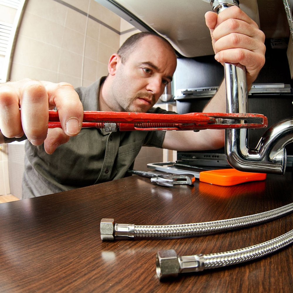 Plumber fixing sink with wrench