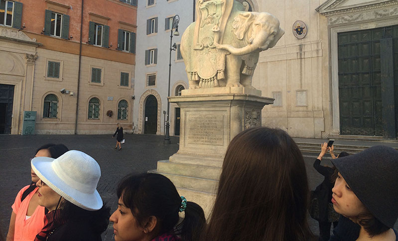 students gathered in front of a elephant statue