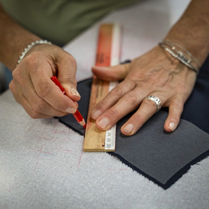 Close-up of an artisan marking fabric with precision before tailoring, reflecting Don Marrón’s commitment to Italian craftsmanship and detail.