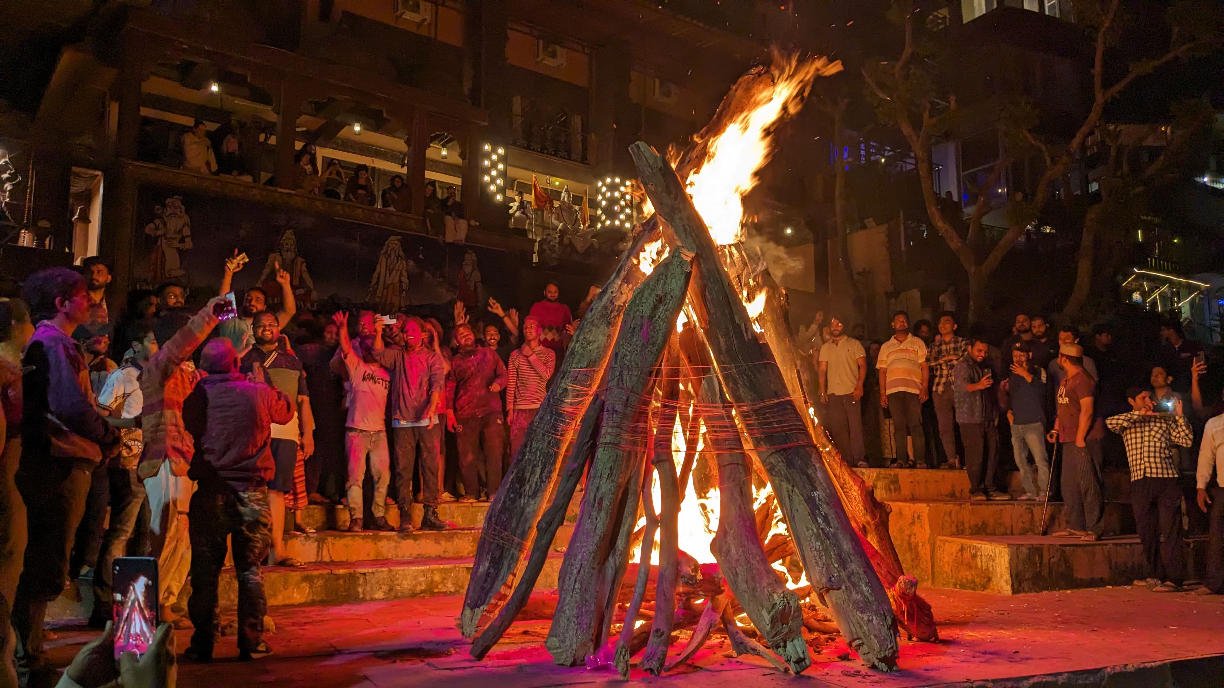 A bonfire with people around in a ghat of Rishikesh (India) during Holi festival of colors