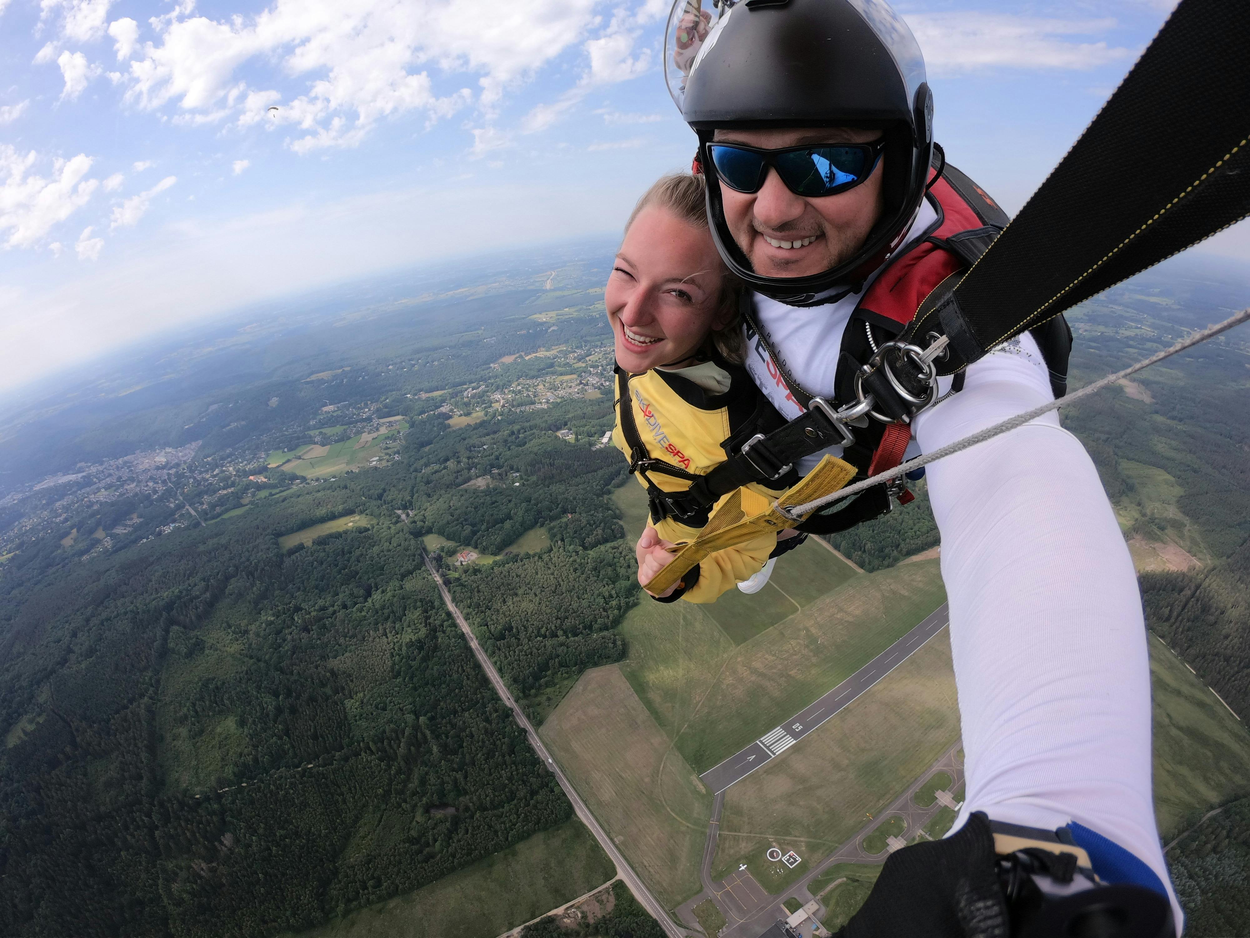 A woman and man taking a selfie as they skydive.