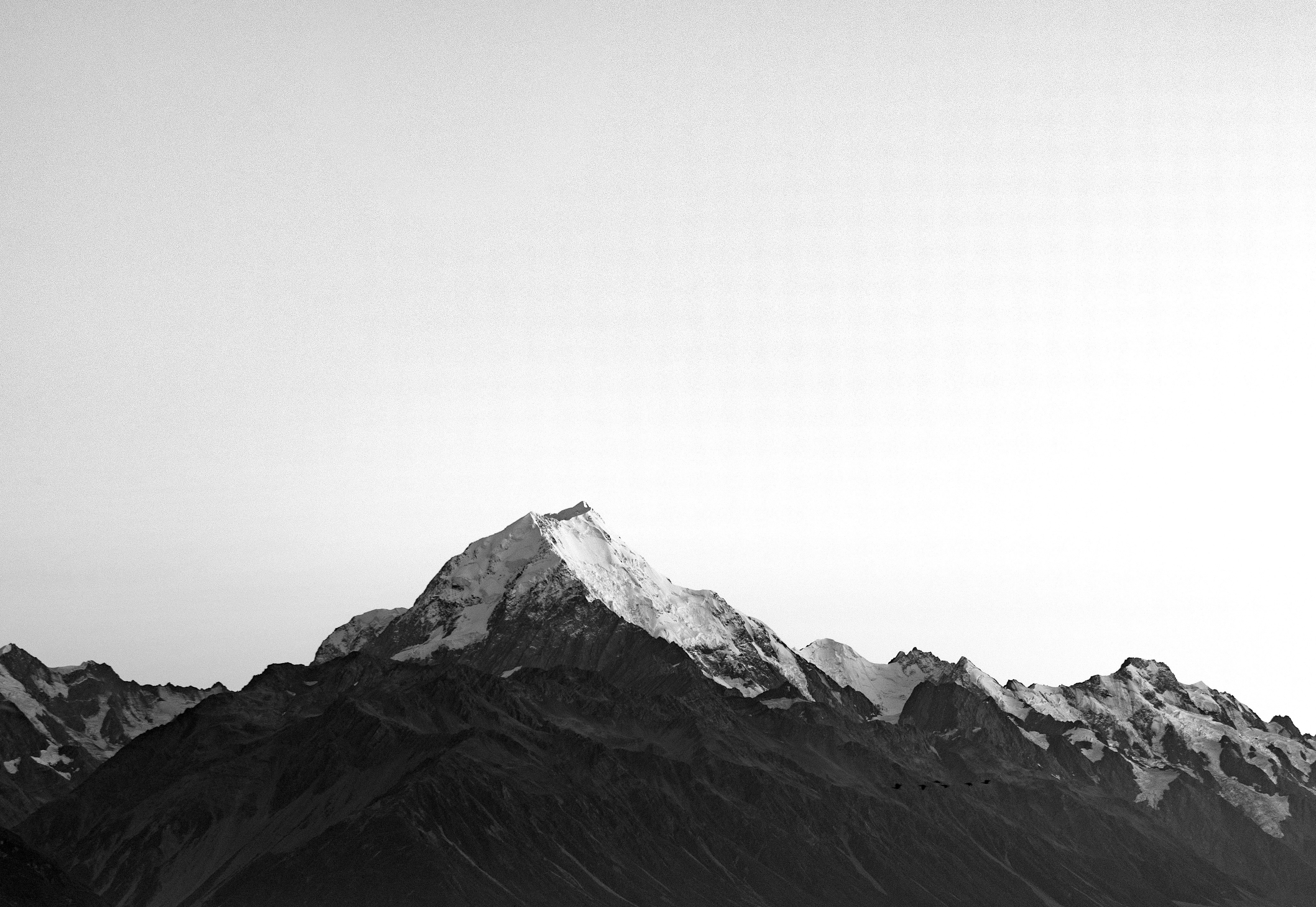 Snow-covered mountain range under an overcast sky in New Zealand