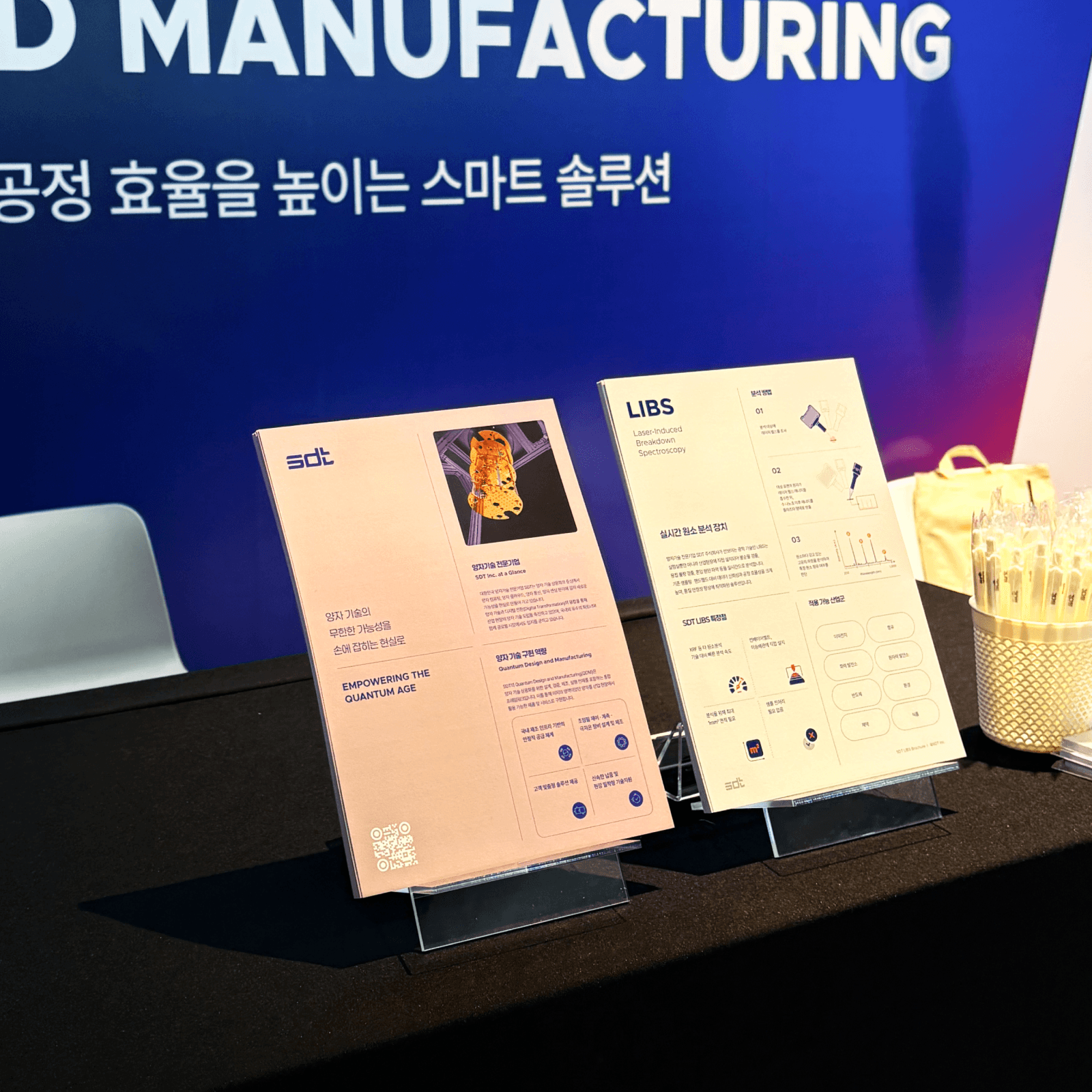 인터배터리 2026 전시회에서 SDT(에스디티)가 배터리 제조 공정의 품질을 분석하는 실시간 원소 분석 장비 LIBS와 하이브리드 양자 컴퓨팅 클라우드 서비스 큐레카(QuREKA)의 제품소개서를 제공하고 있다.