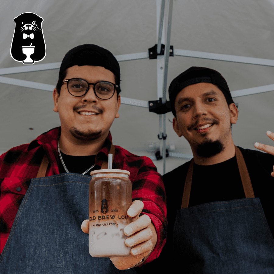 Lou and Josuse holding a cold brew cup with their otter logo on the right corner and cold brew lou written in front