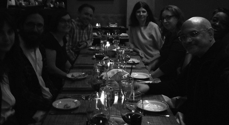 a black and white picture of people sitting at a table