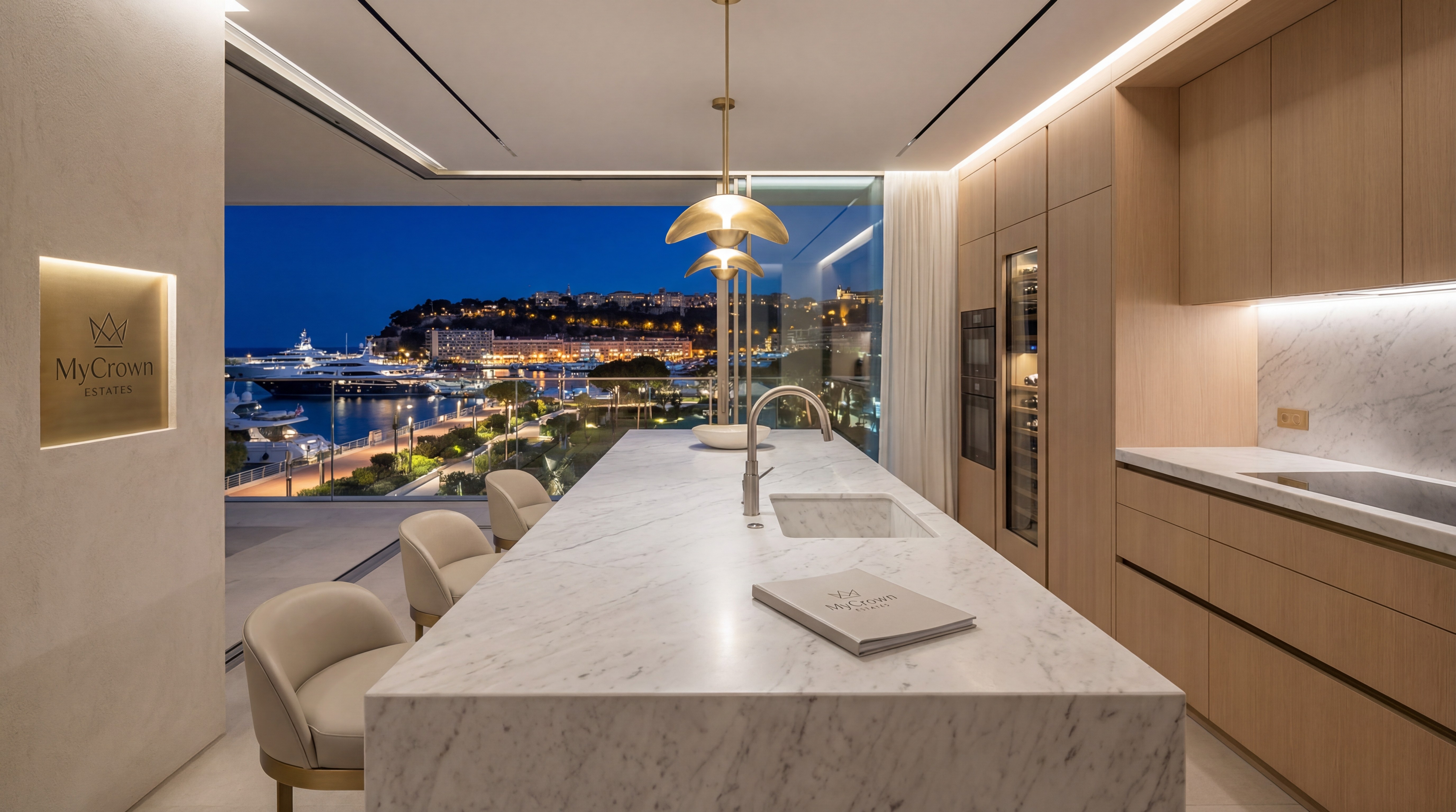 Cuisine de prestige avec îlot en marbre et vue nocturne sur le quartier de l'Anse du Portier et le Rocher de Monaco.