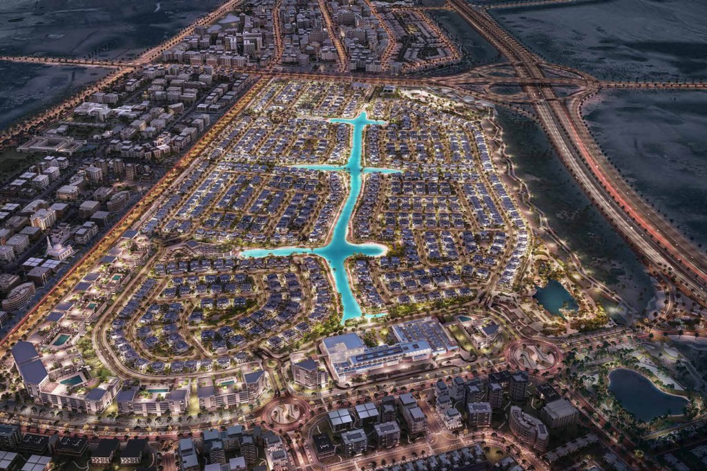 Aerial view of Dubai's South Bay, showcasing modern buildings rising from the vast desert landscape.