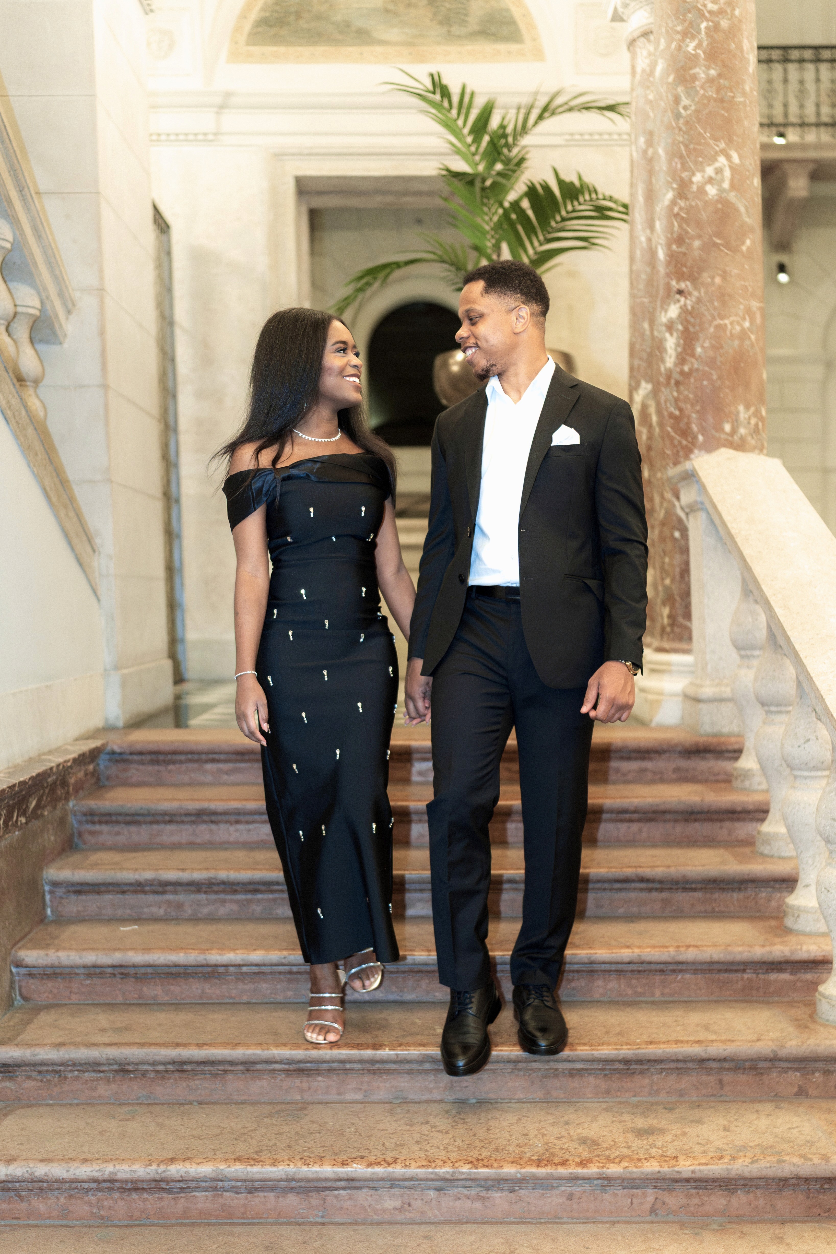 A beautifully set dining table with white tablecloth, cutlery, and fresh greenery in a cozy, well-lit space.