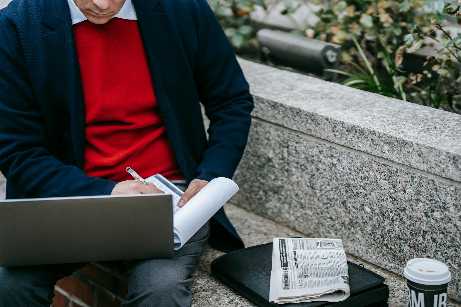 Man taking notes in front of his laptop
