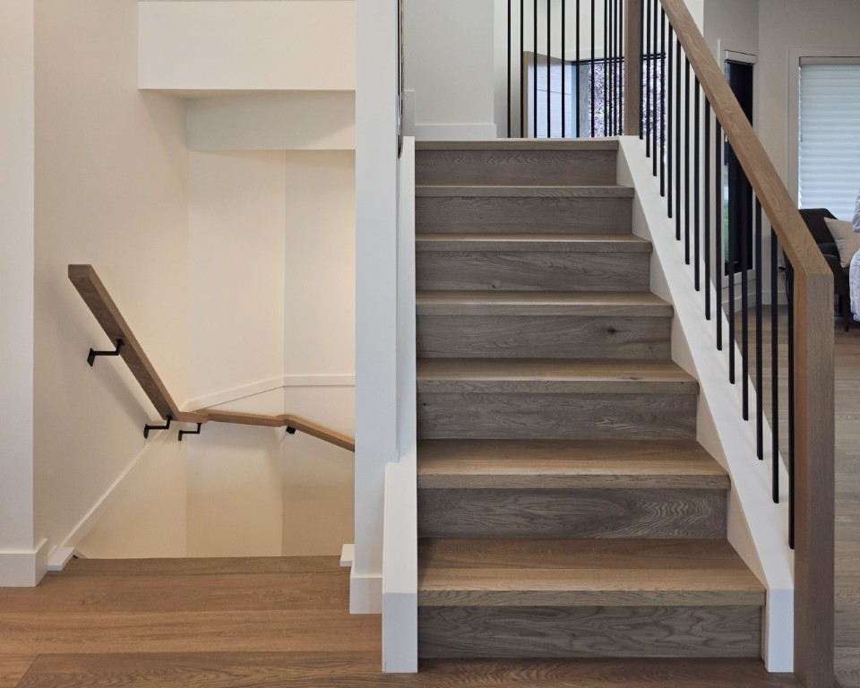Image of Modern staircase with wooden steps and black metal railing, showcasing KHD Homes' interior design and construction.