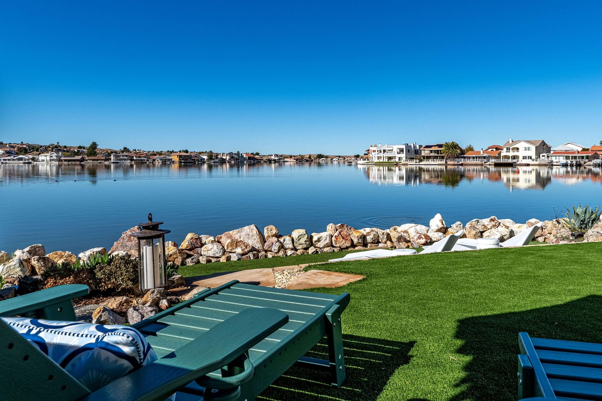 Backyard view, onlooking the lake in the backyard with Teal-blue chair in the foreground.