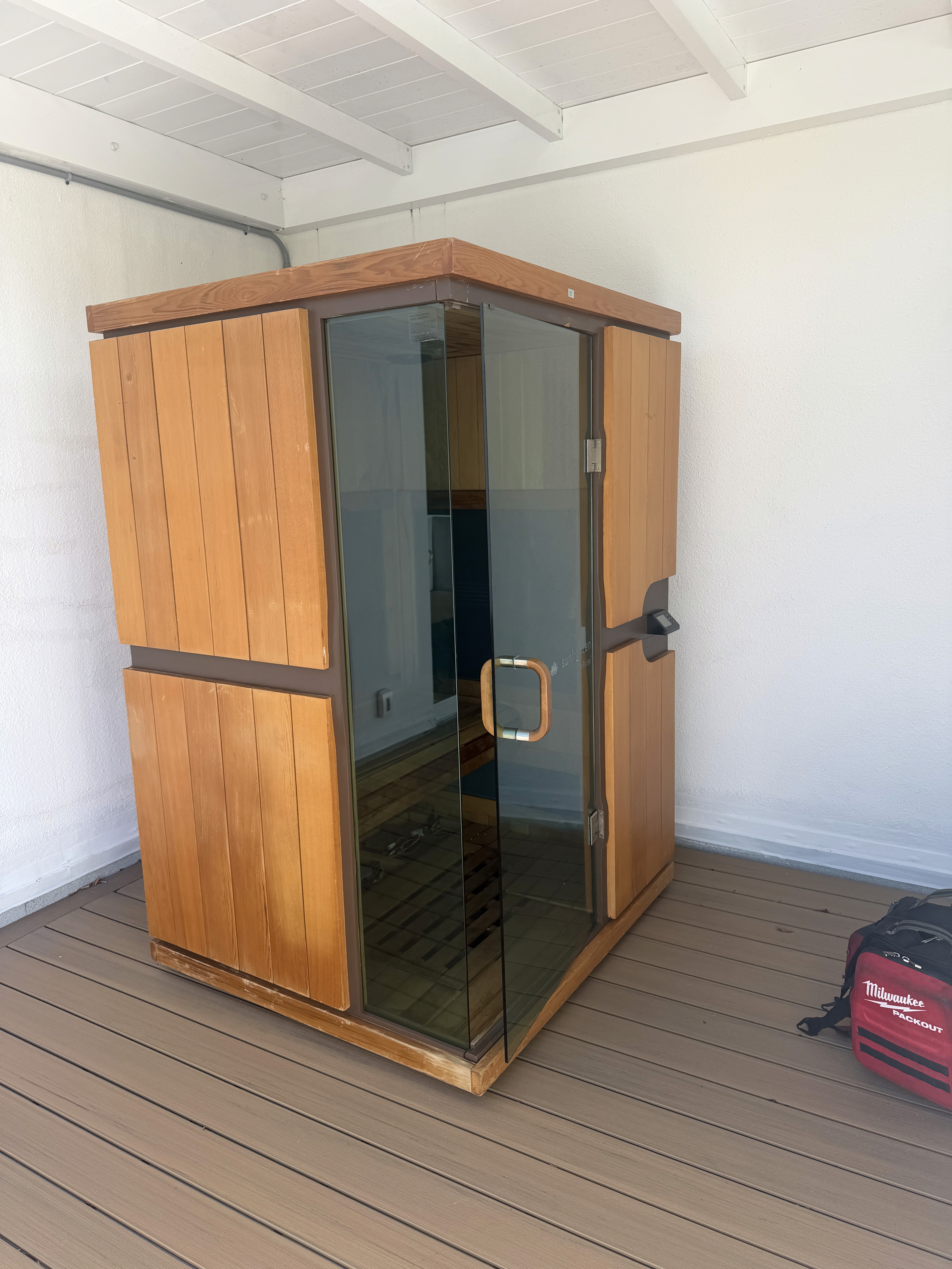 Side view of a Sunlighten mPulse infrared sauna on a covered patio