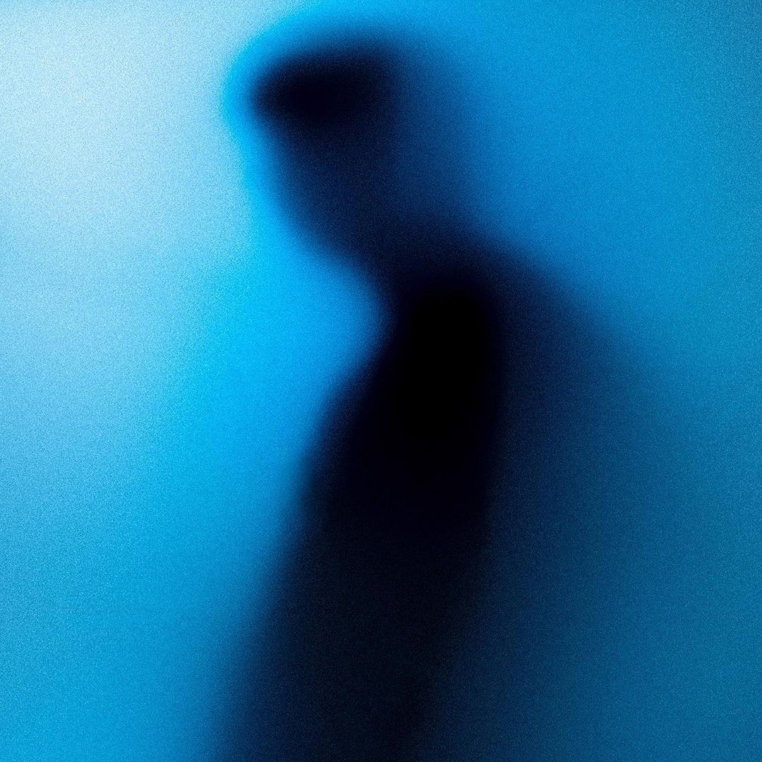 a blurry photo of a person standing in front of a wall