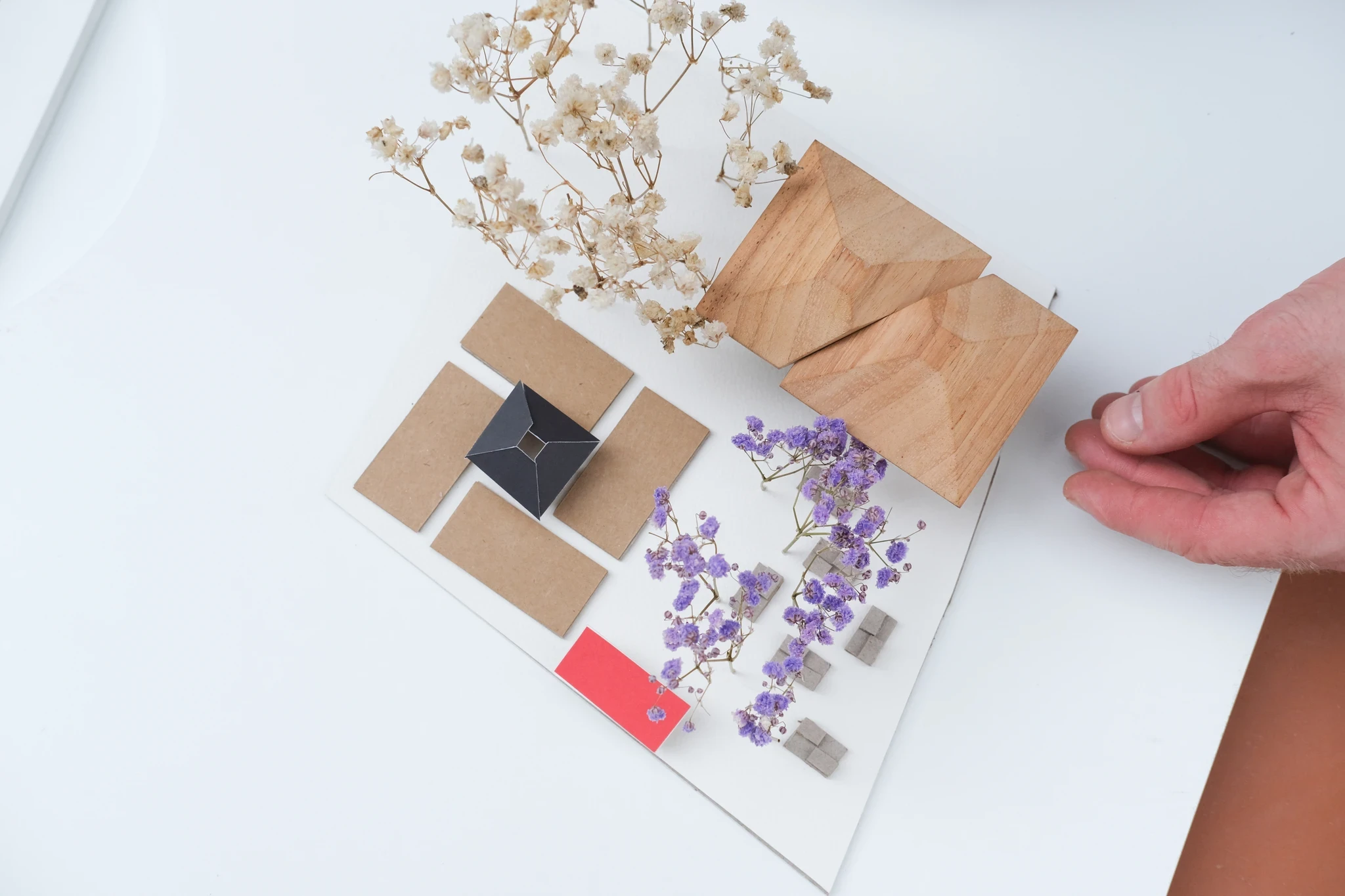 Conceptual material display for a community market project, showing dried floral elements and packaging, hinting at artisanal products available.