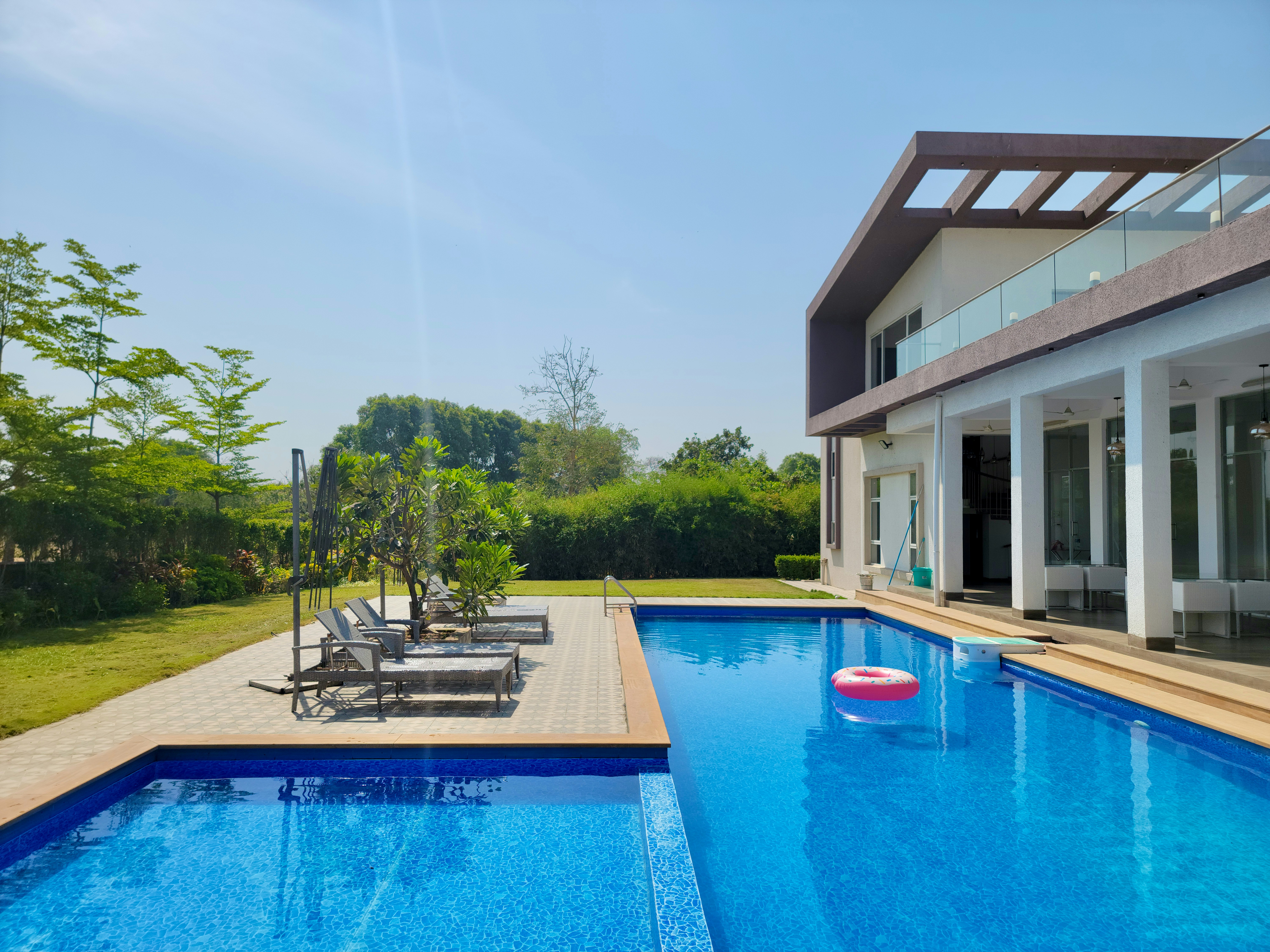 a large swimming pool with lounge chairs and a deck