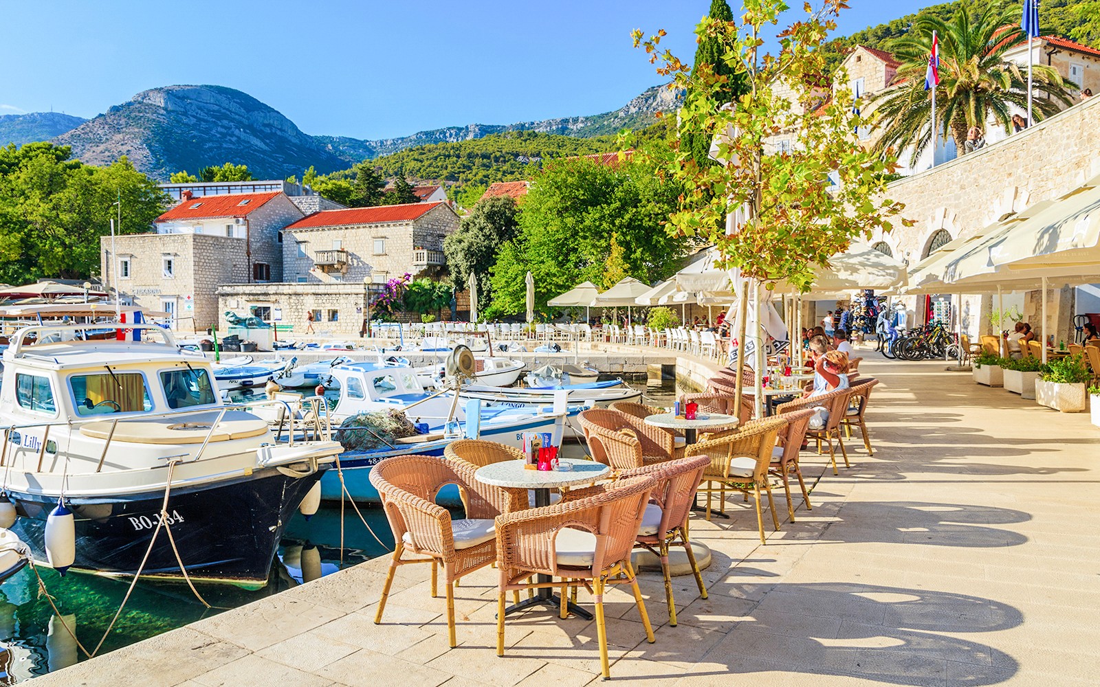 Hamnutsikt med båtar och utomhusplatser på café på Hvar-ön, Kroatien.