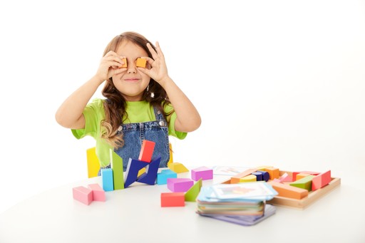 A girl playing with colourful play blocks