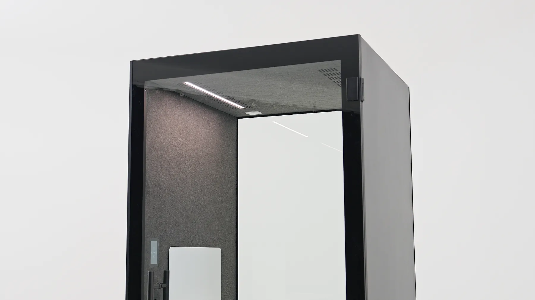 Corner view of a Silen pod interior showing the ceiling light and glass door