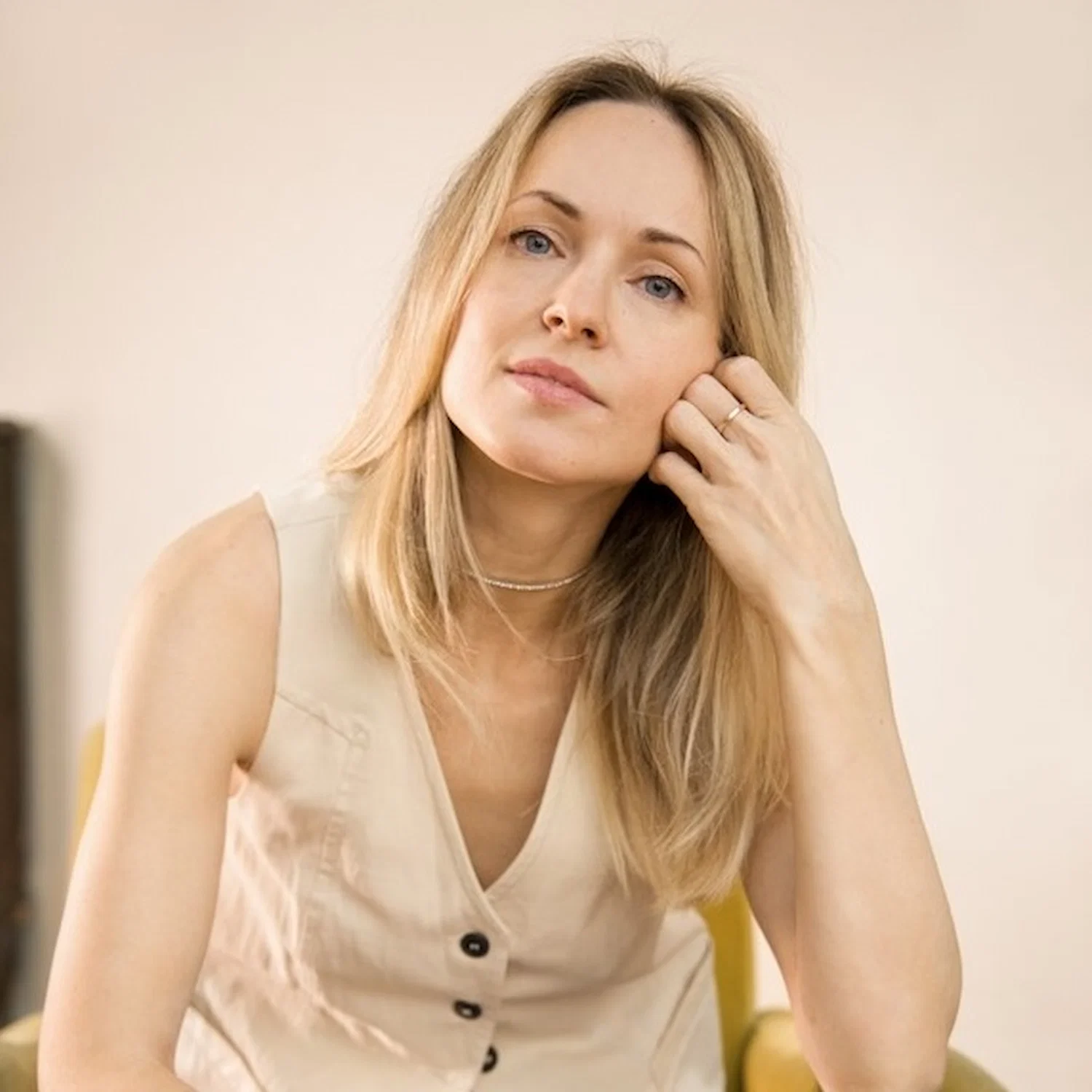 Calm woman sitting thoughtfully indoors, representing resilience and healing through LGBTQ trauma therapy in Los Angeles.