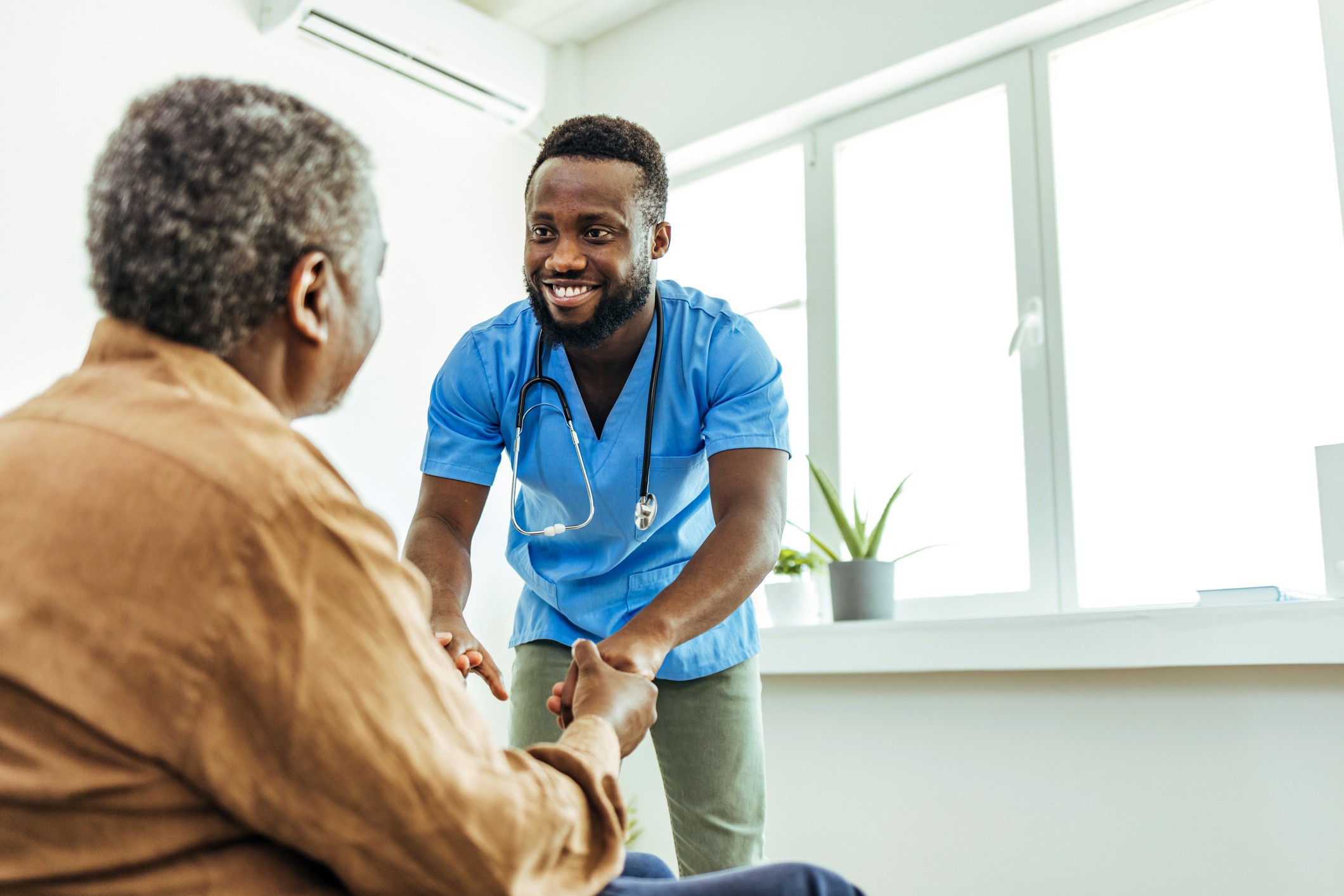 Doctor and patient holding hands after good news