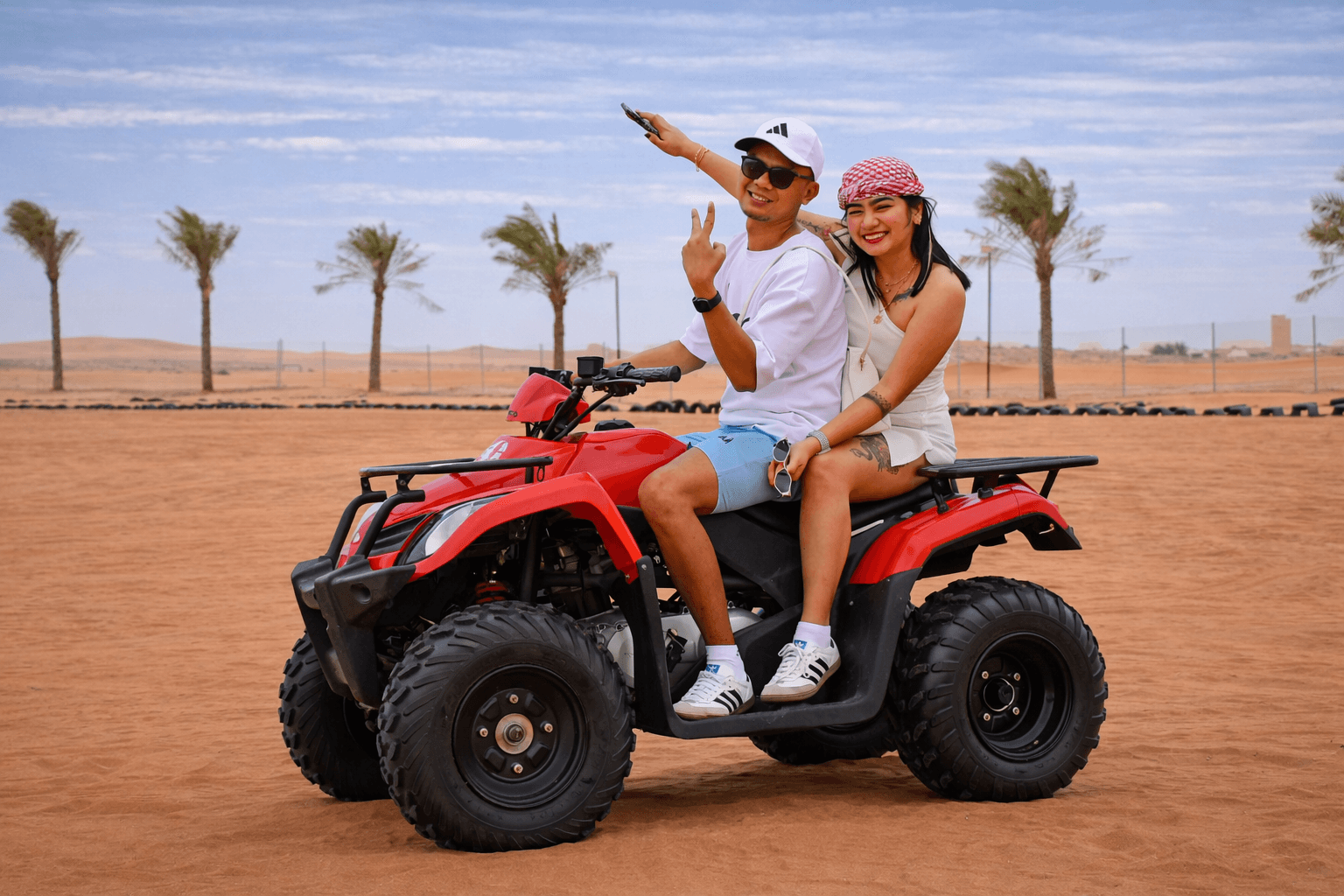 Couple enjoying an ATV ride during a Dubai desert safari experience with Dune Quest Tours