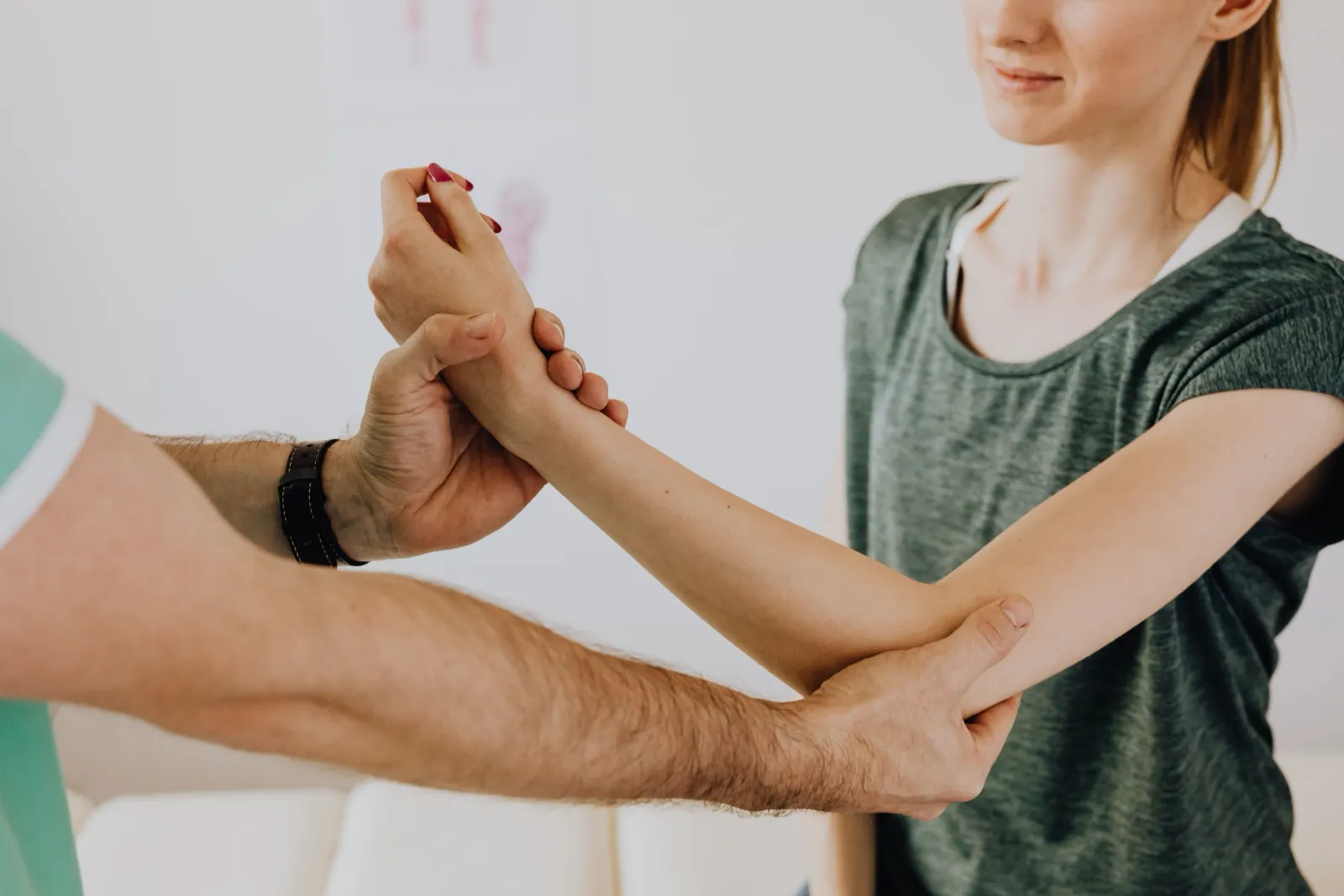 Therapist supporting a woman’s wrist and arm during treatment