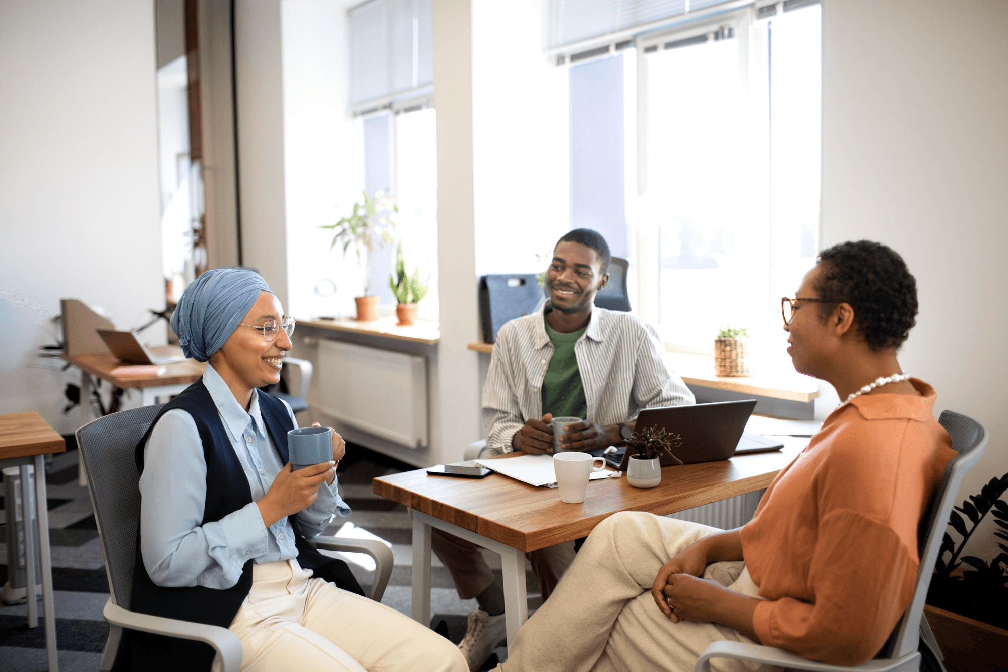 Three people have in a sync meeting in an office
