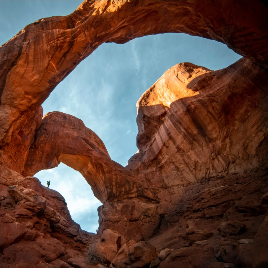 Rock formation under white clouds and blue sky in Arches National Park, UT