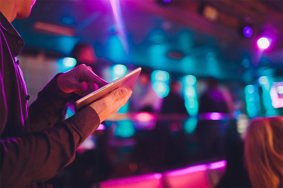 Venue manager looking at Sellout app on tablet.