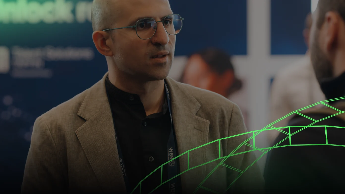 Man speaking at an event with a green graphic overlay