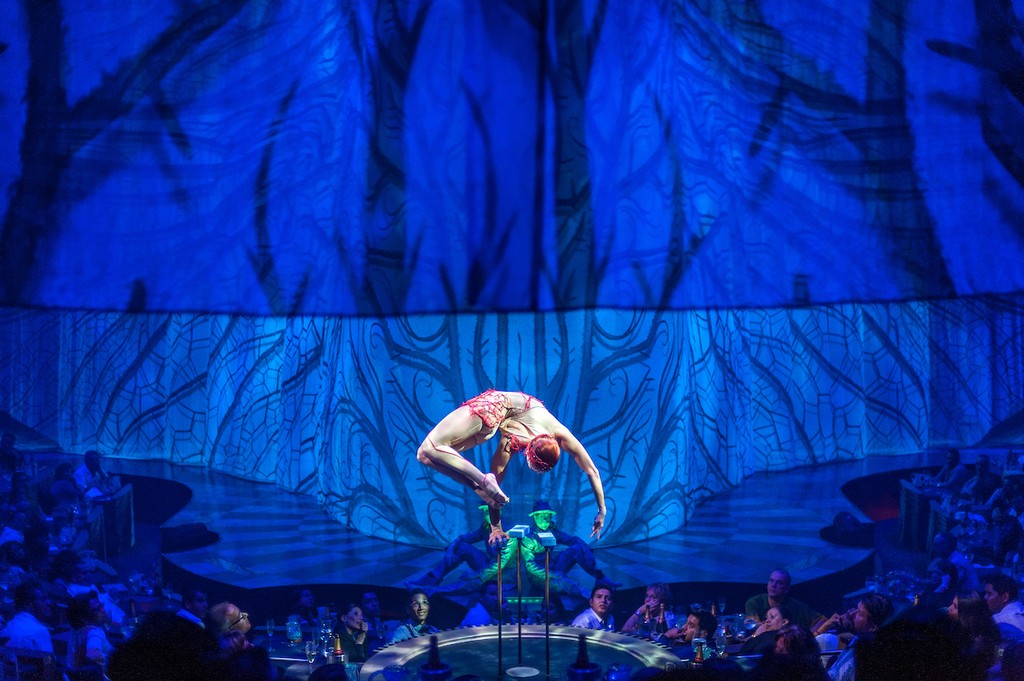 Couple standing on a balcony with binoculars in hand looking out over the ocean