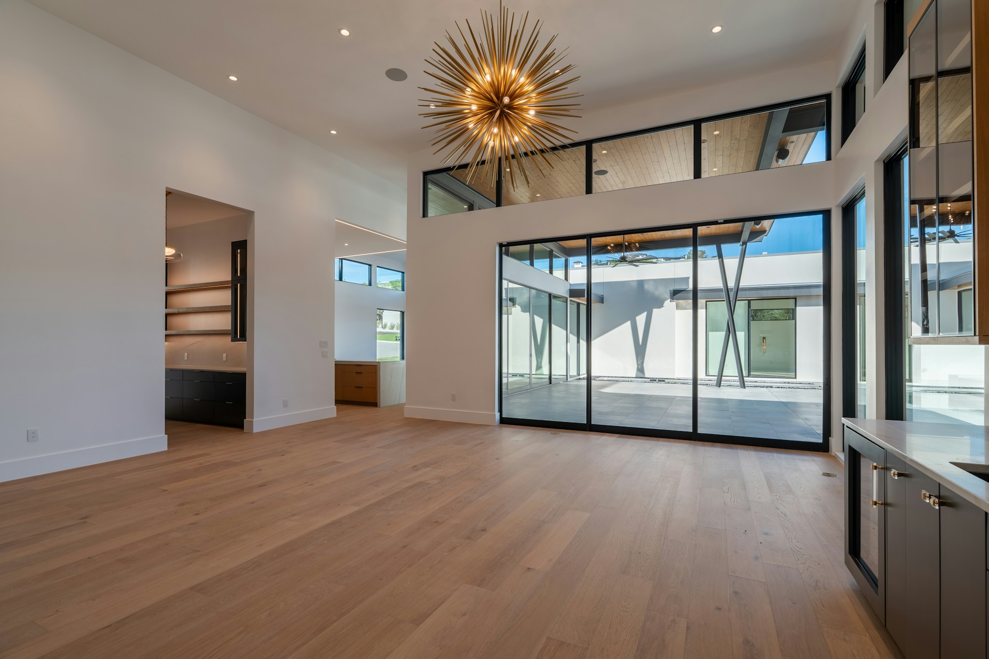 After: open living room with wood floors and a wall of glass doors