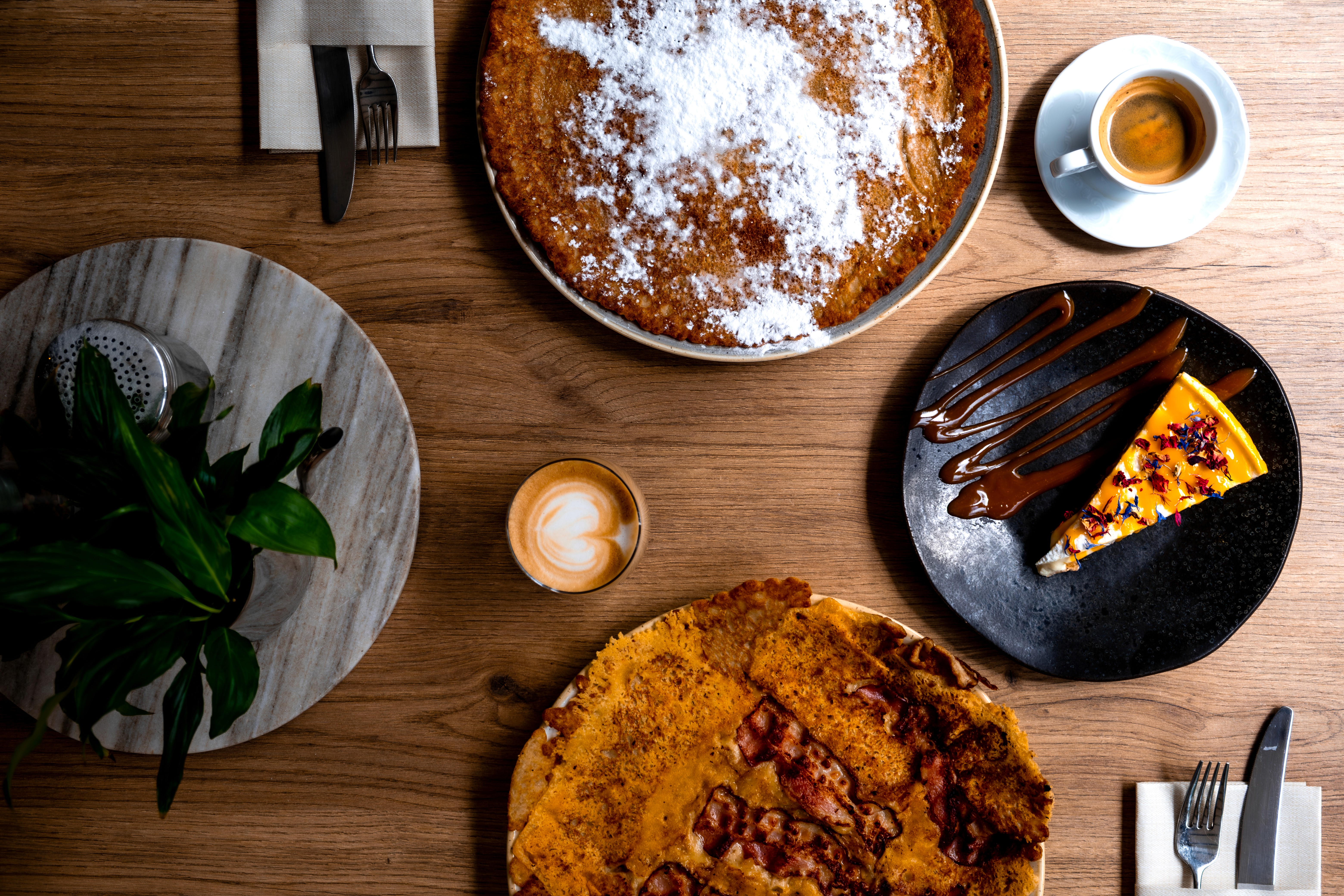 Verse pannenkoeken , lemoncheesecake en koffie op tafel bij Pan & Cook in Prinsenbeek.