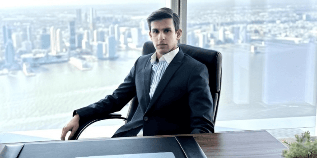 Aditya Raj Kothari, CEO of Vasundhara Ananta Natural Resources Inc., confidently sits at his desk with a city skyline in the background.