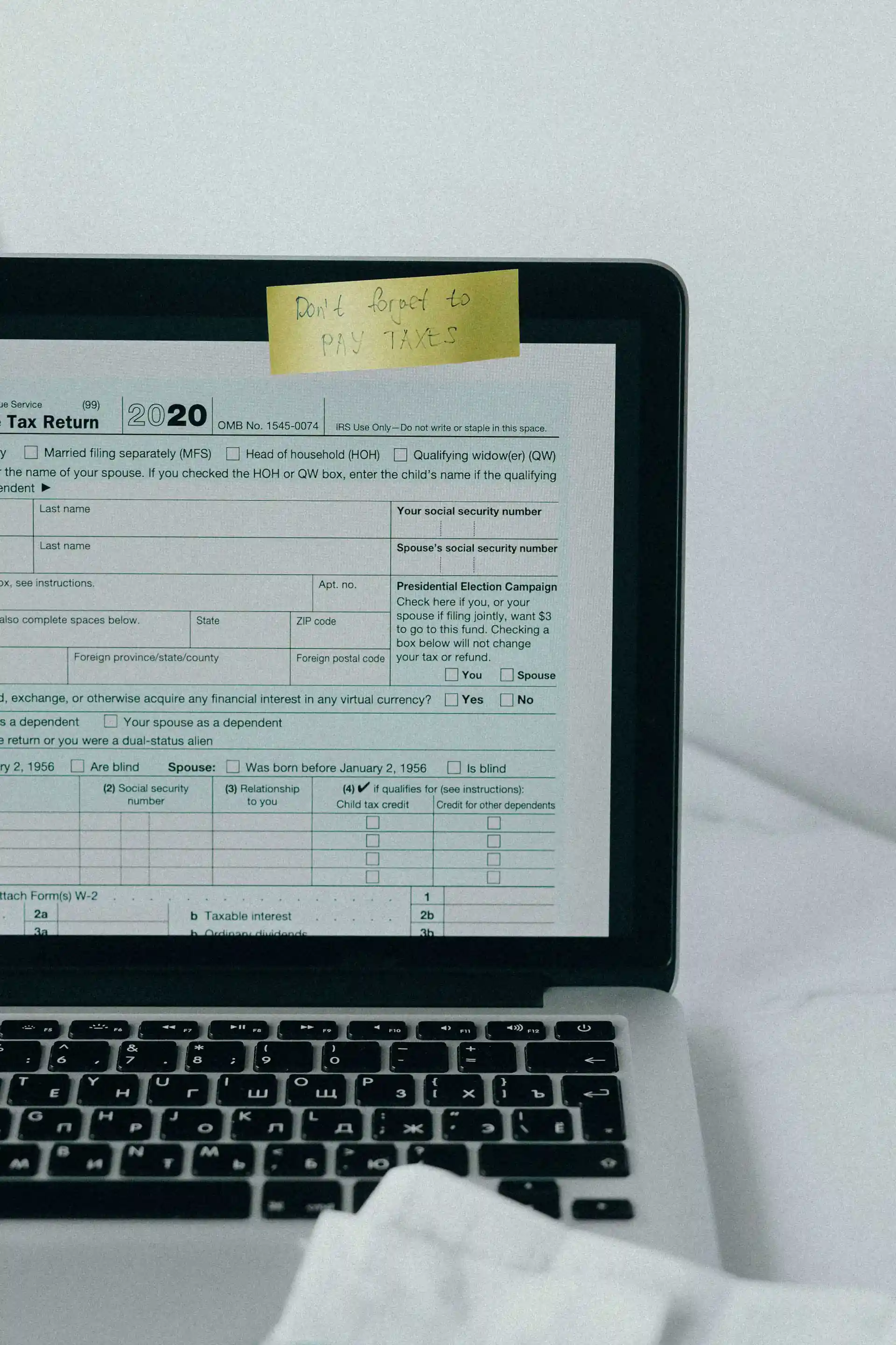 Laptop displaying 2020 tax return with note