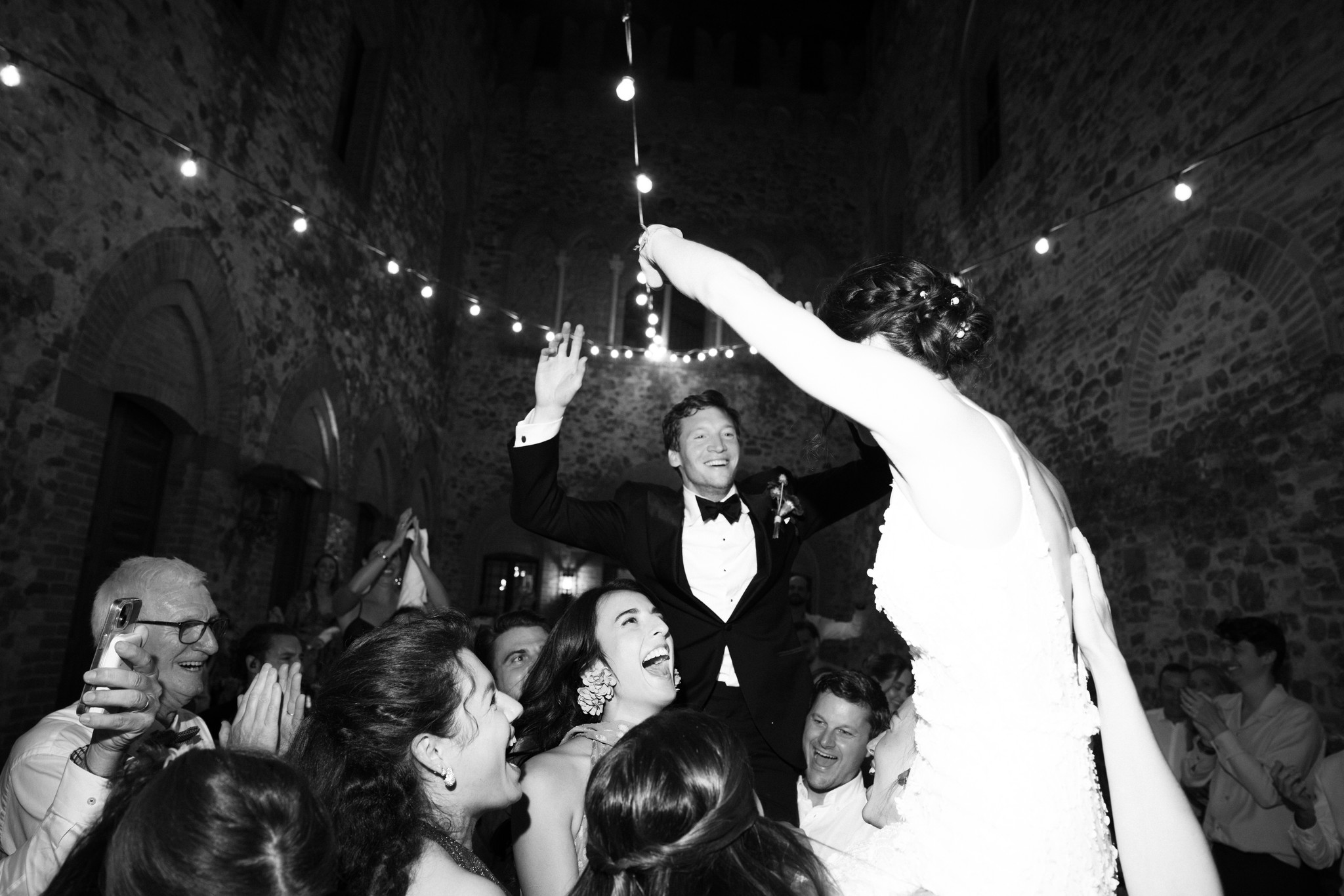 Sposi lanciano bouquet sotto le volte del Castello di Tabiano, ospiti festeggiano al ricevimento di matrimonio