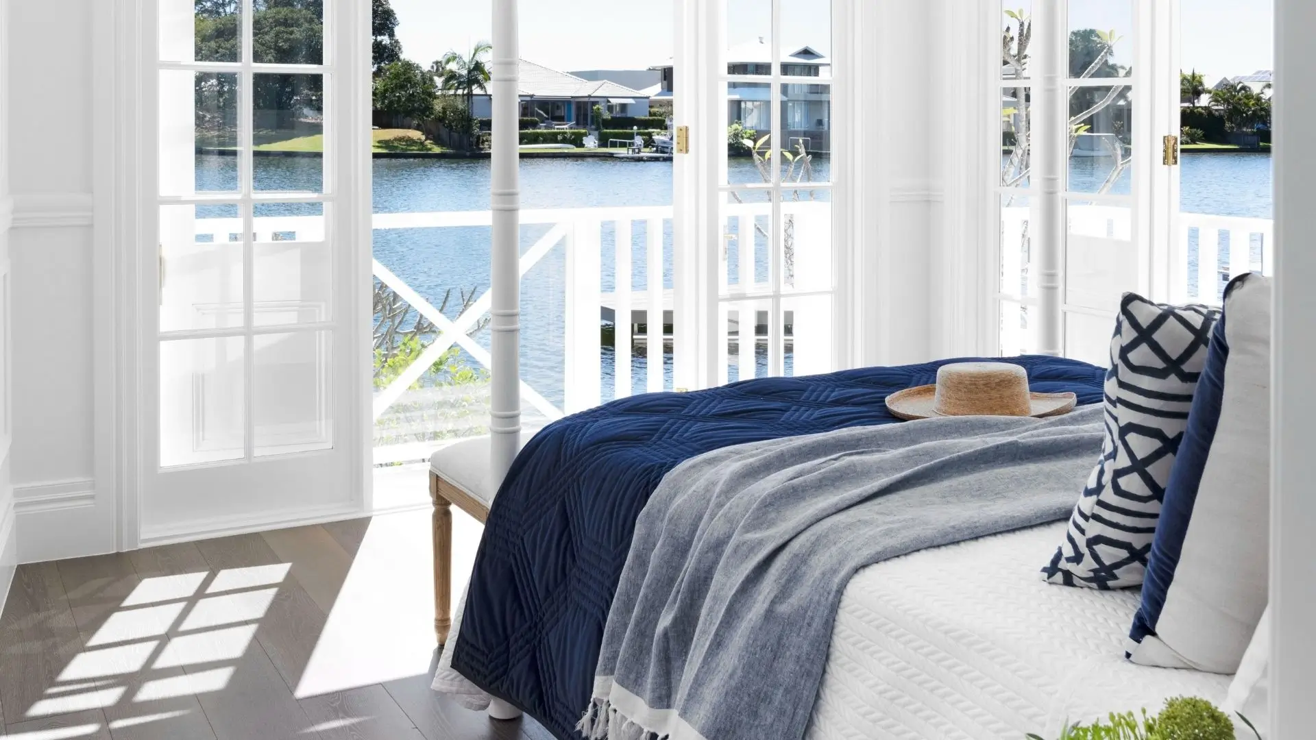 Luxurious master suite with floor to ceiling glass with water views