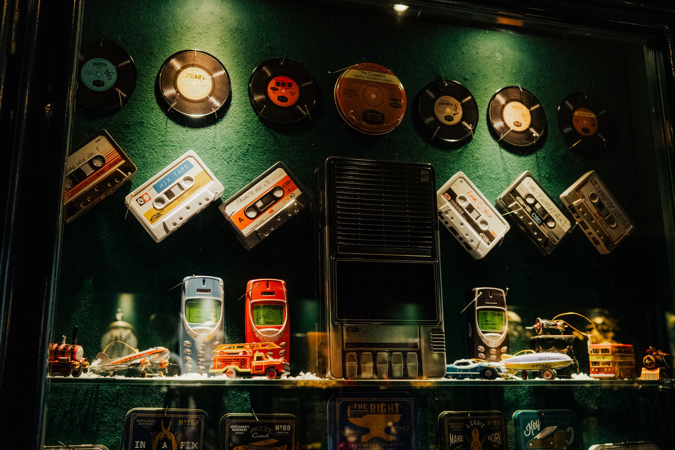 Escaparate con discos, casetes, móviles antiguos y juguetes de lata