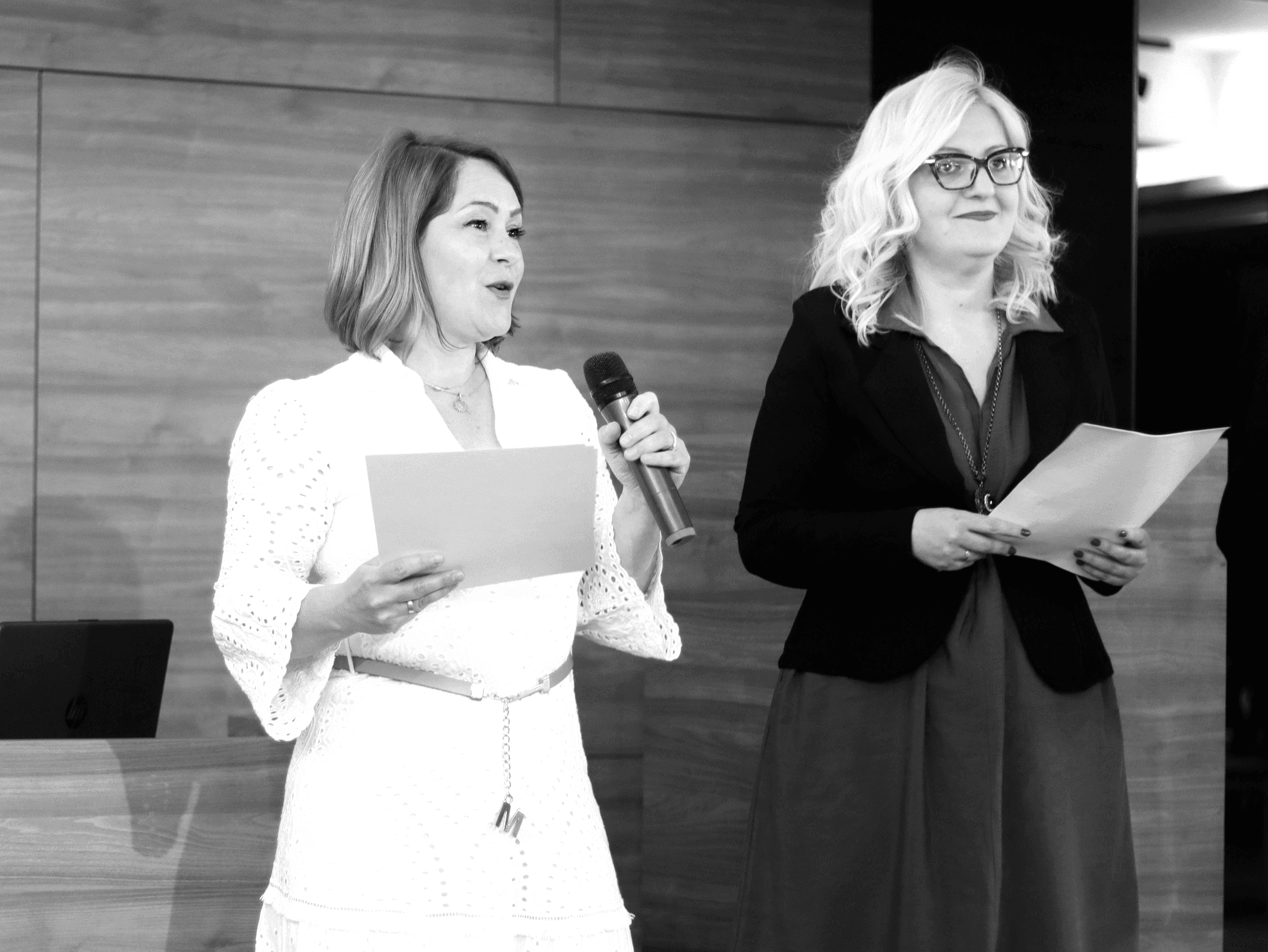 a woman standing next to a woman holding a microphone