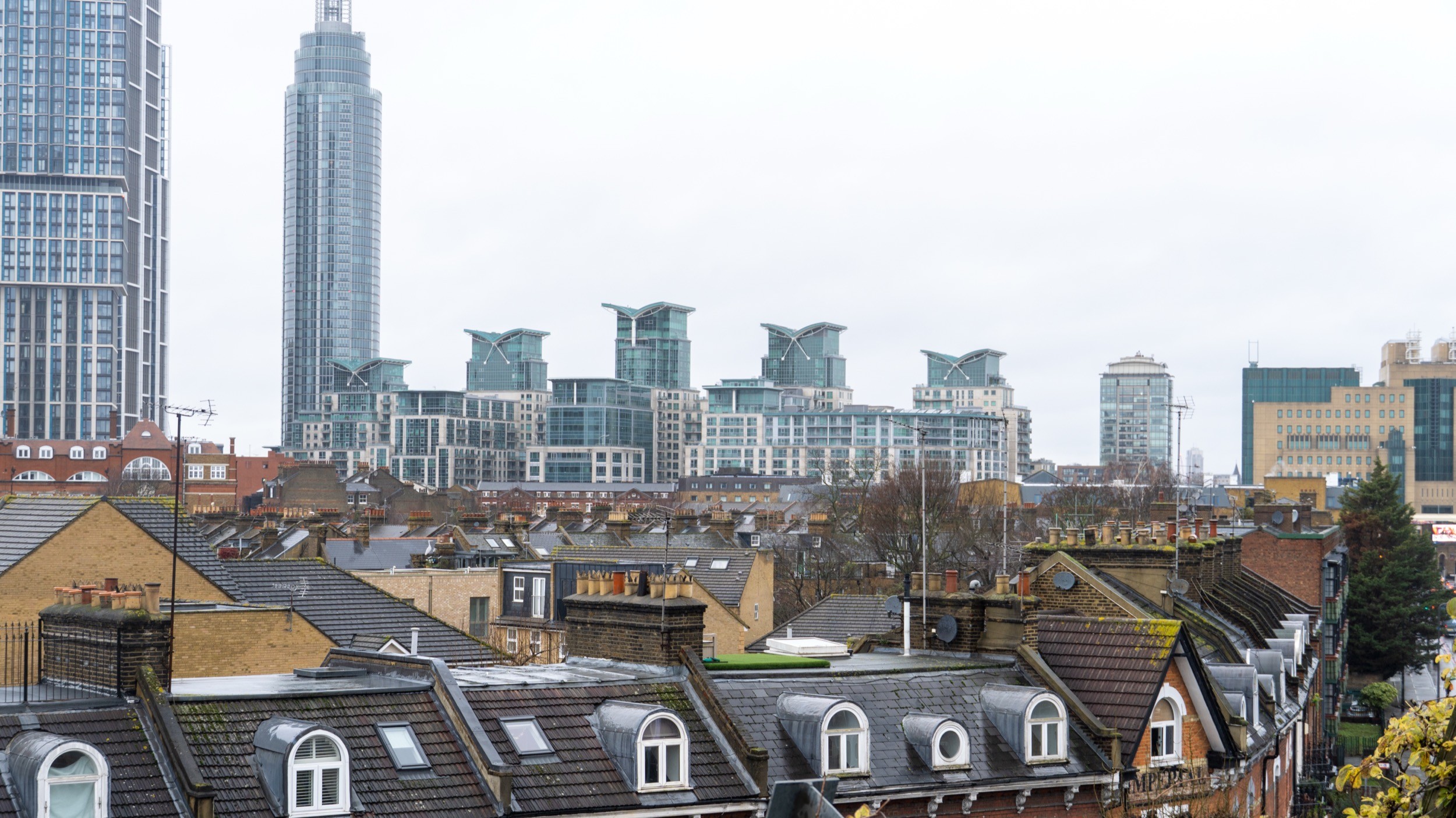 Two classic volkswagen beetles, one green, one cream.