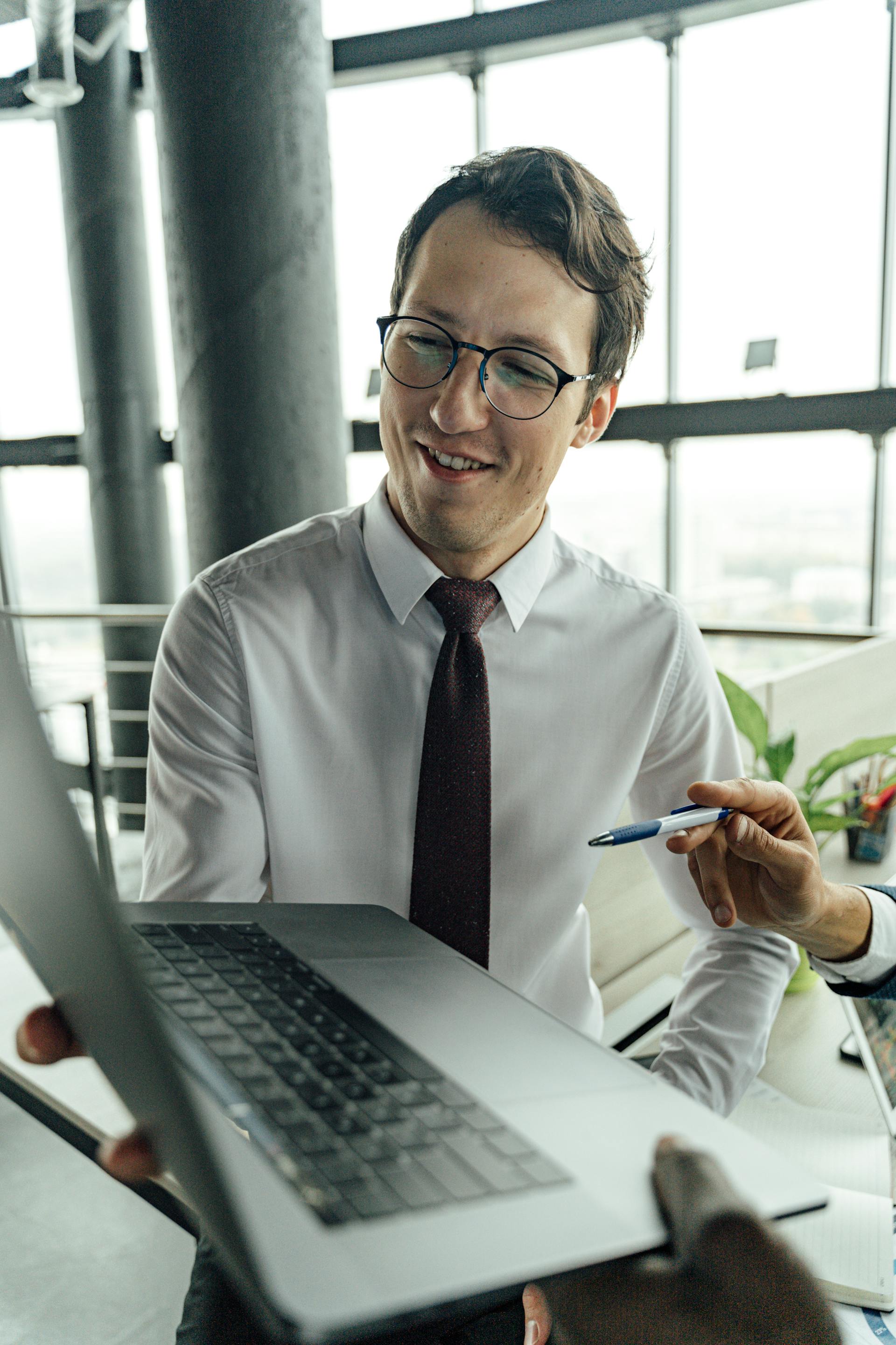 Office worker showing a coleague something on his laptop