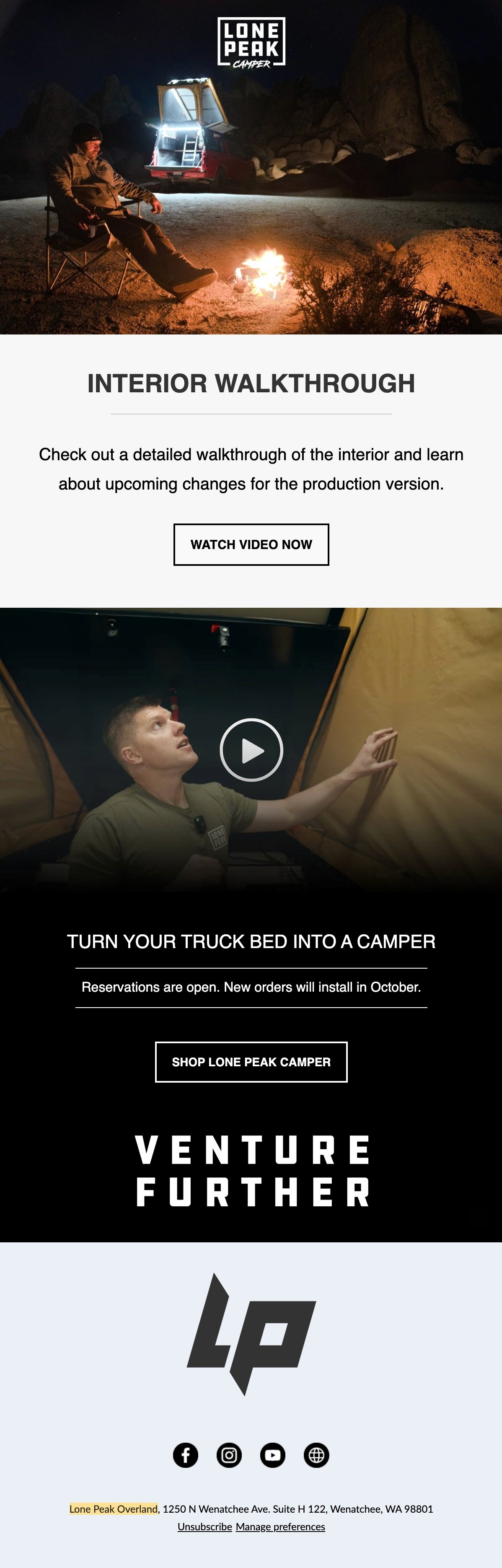 Black and white photo of two people looking at a computer screen with papers on wall