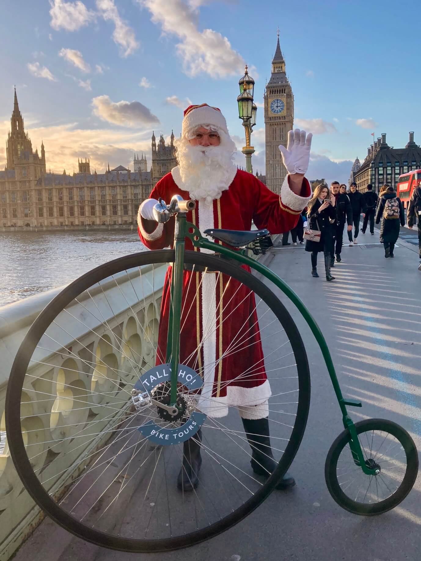 Tally-ho Santa with a penny farthing waving in front of Big Ben 