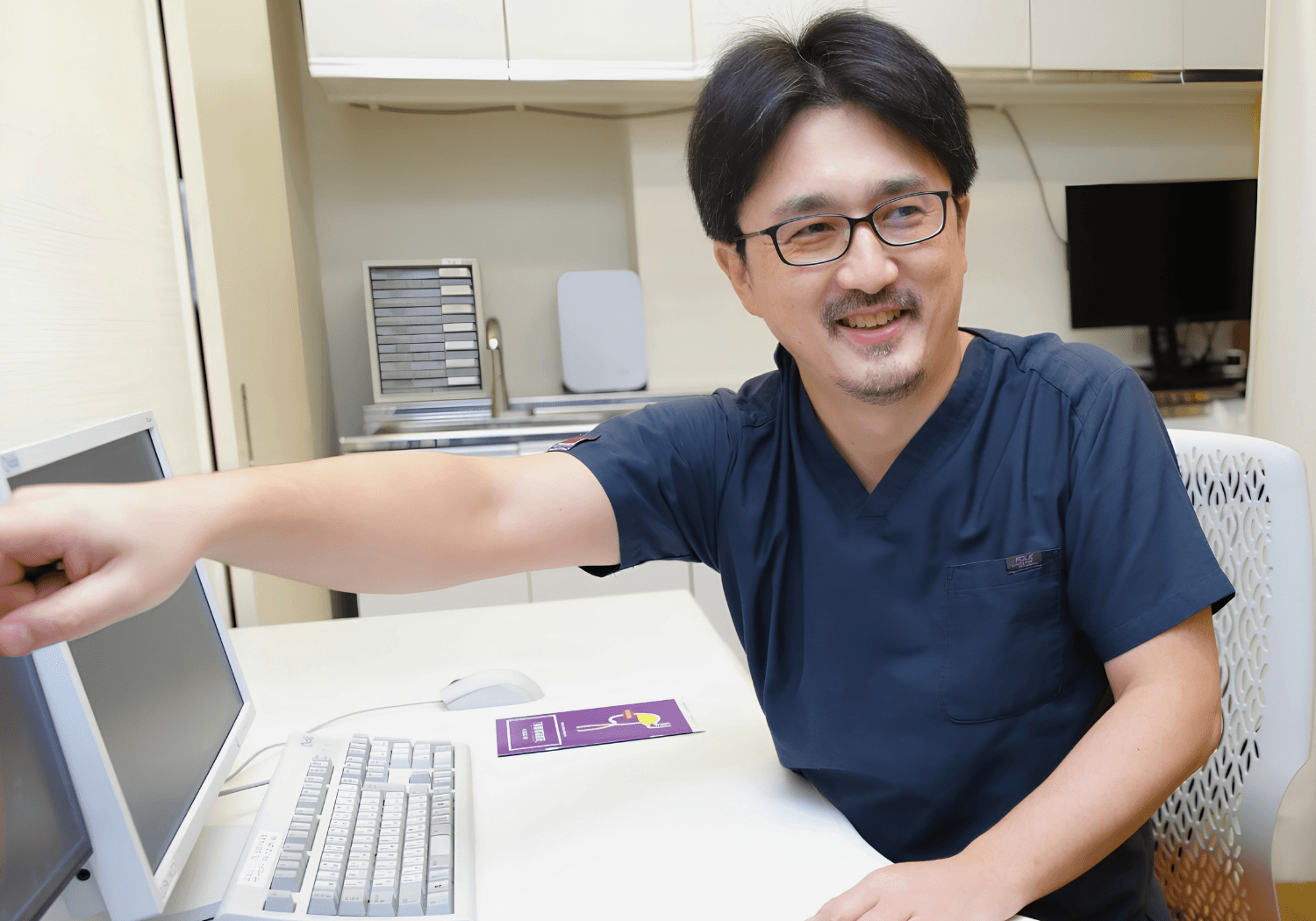 診察室でモニターを指差しながら説明する吉良文孝先生