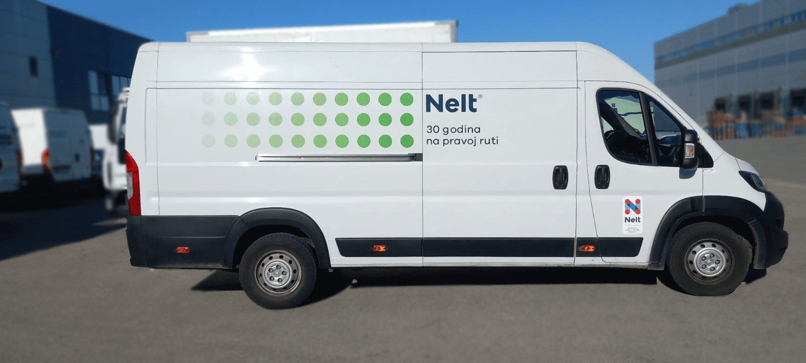 Bela dostavna kombi vozila brendirana logotipom Nelt i zelenim tačkama