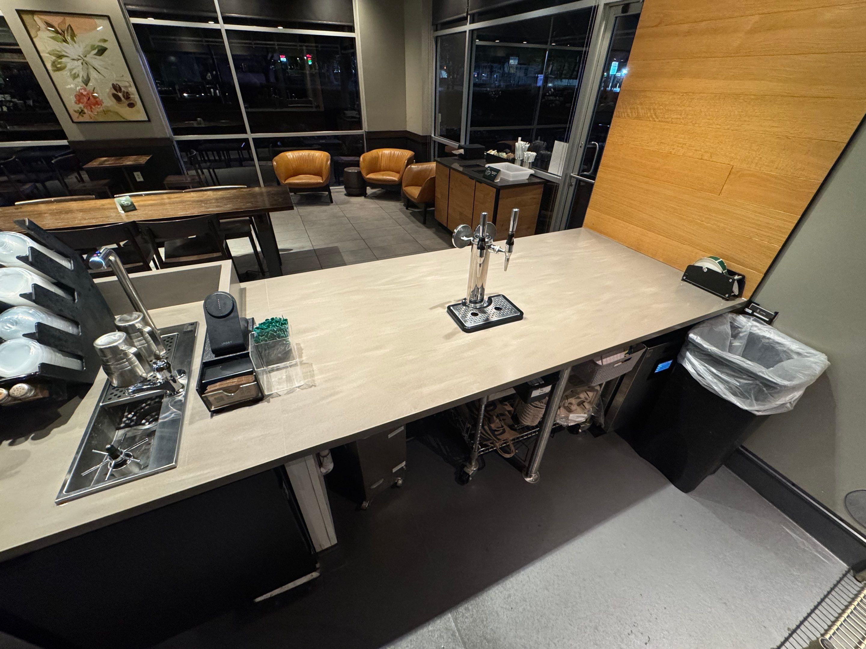 Corner section of a Starbucks countertop replacement featuring new surface installation around tap system and prep area with clean, durable finish.