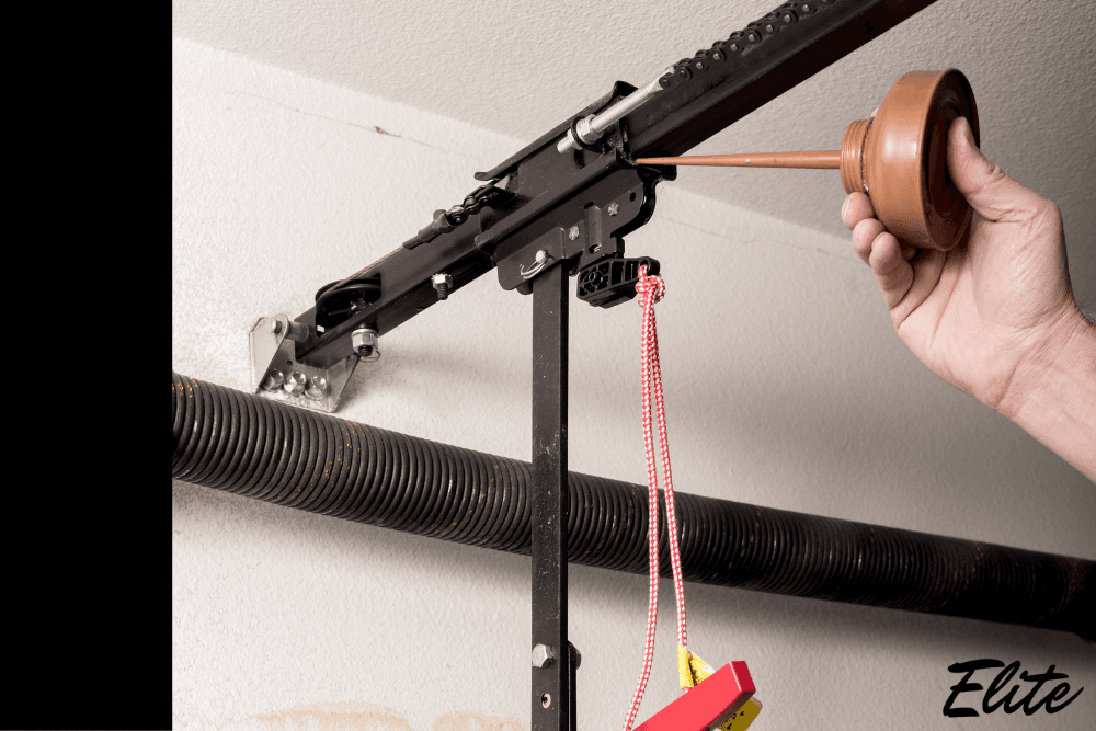 Close up of garage door springs being lubricated for winter by Elite Garage Door in NWA.