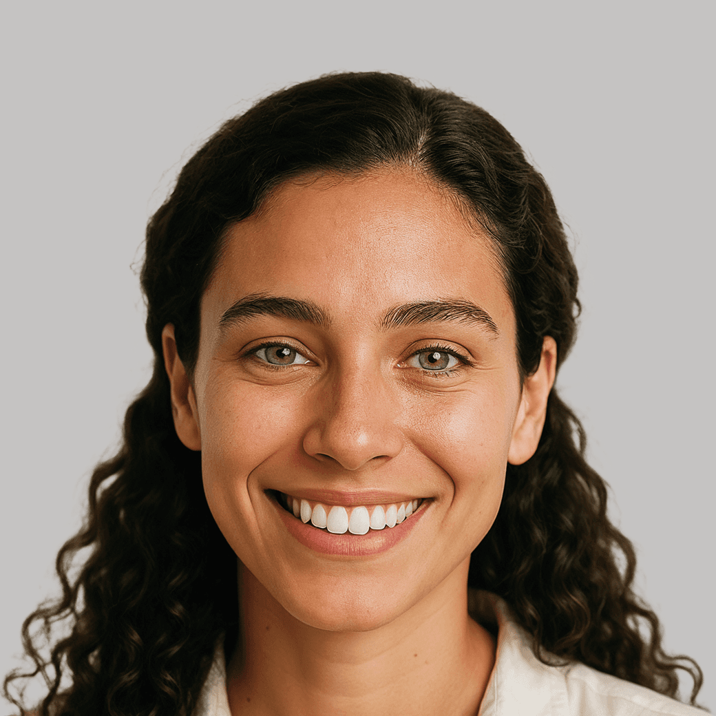 Portrait of a smiling woman with curly dark hair and olive skin
