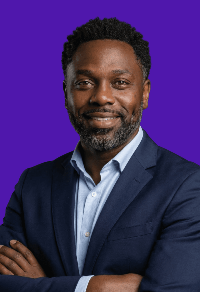 Portrait of a laughing person with curly hair wearing a white shirt